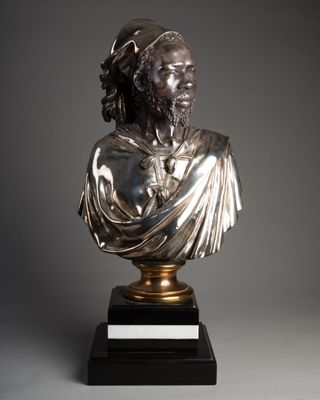 un buste en bronze représentant un homme barbu et coiffé d'un chapeau