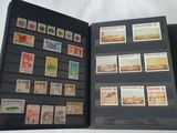 a black folder with stamps on it on a bed