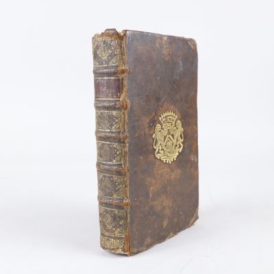 un vieux livre orné d'un médaillon doré sur la couverture