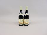 deux bouteilles de vin posées l'une à côté de l'autre sur une surface blanche