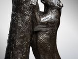 bronze sculpture of two dogs playing with each other on a marble base