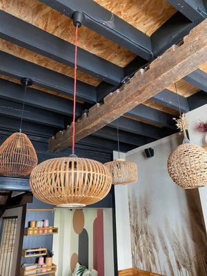 a room with a table, chairs, and a lamp hanging from the ceiling