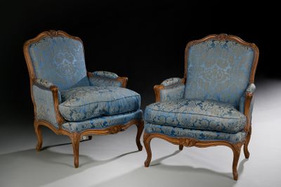 une paire de fauteuils rembourrés bleus dans une pièce sombre