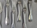 a lot of forks and spoons that are on the table
