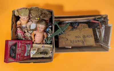 a box full of dolls and other items on a yellow surface