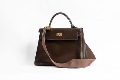 un sac à main marron sur fond blanc, muni d'une bandoulière marron