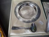a silver plate with a spoon and a spoon rest on a tray