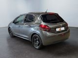 the back of a silver car in a room with a white wall