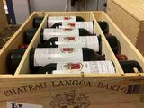 plusieurs bouteilles de vin se trouvent dans un coffret en bois sur une table