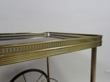 gold metal bar cart with glass top and wheels