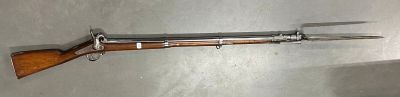 un fusil accroché au mur, sur lequel est posé un couteau