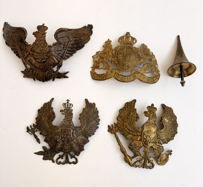 Plusieurs objets anciens en métal sont exposés sur une surface blanche