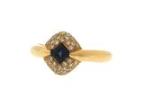 un gros plan d'une bague en or sertie d'une pierre bleue entourée de diamants