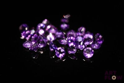 un gros plan sur un bouquet de cristaux violets posés sur une surface noire