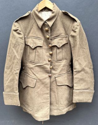 une vieille veste militaire suspendue à un cintre accroché au mur
