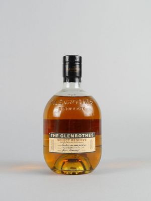 une bouteille de whisky single malt Glenmores posée sur une surface blanche
