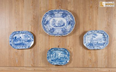 Quatre assiettes bleues et blanches sont accrochées à un mur en bois.