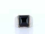 a close up of a ring with a black stone in it