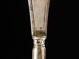 a silver spoon with a silver handle on a black background