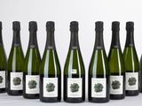 six bouteilles de vin sont alignées sur une table