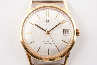 une montre-bracelet en or avec un cadran blanc sur une surface blanche