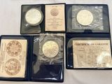 four different types of silver coins in plastic cases on a table