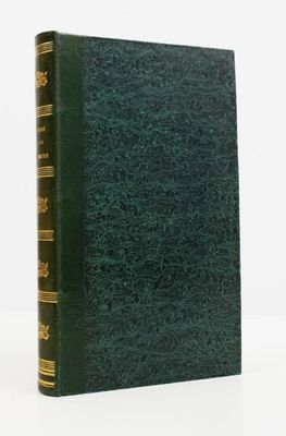 un vieux livre à la couverture verte posé sur une surface blanche