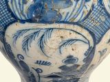 a blue and white vase with a gold lid