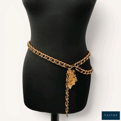 a black mannequin torso with a gold chain belt