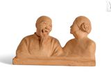 une sculpture en argile représentant un homme et une femme assis sur un banc