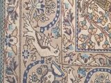 an antique persian rug with a blue border and floral design