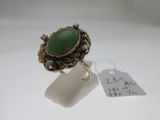 a close up of a ring with a green stone on it