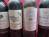 several bottles of wine are lined up on a red table