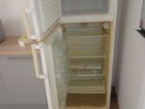 an open refrigerator in the corner of a kitchen
