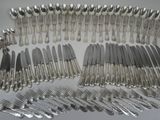 many forks and spoons laid out on the table