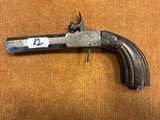 un vieux pistolet avec une étiquette, posé sur une table