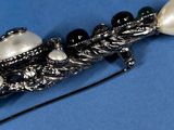 a close up of a brooch with pearls on it