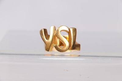un gros plan d'une bague en or sur laquelle est gravé le mot « oui »
