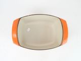 an orange and white bowl on a white surface