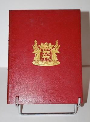 un livre rouge orné d'un blason doré