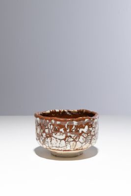 un bol marron et blanc posé sur une table
