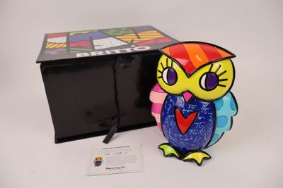 a colorful owl figurine sitting next to a black box
