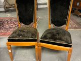 pair of chairs with black velvet upholstered seats in a room