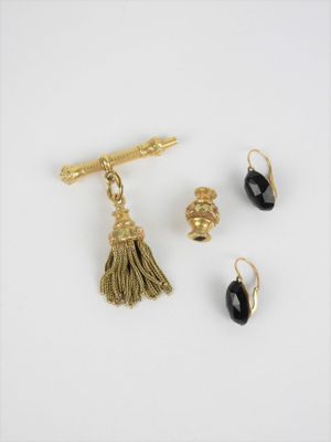 un gros plan sur une paire de boucles d'oreilles et une pince à cravate