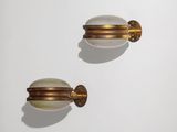 une paire de poignées de porte en laiton et en verre blanc sur un mur blanc