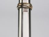 a close up of a silver pen with a gold band on it