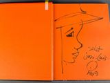 an orange book with a drawing of a woman ' s face on it