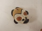 a small panda bear sitting on a table next to a donut