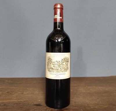 the bottle of wine is sitting on a wooden table