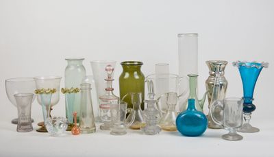 many different colored glass vases on a white surface